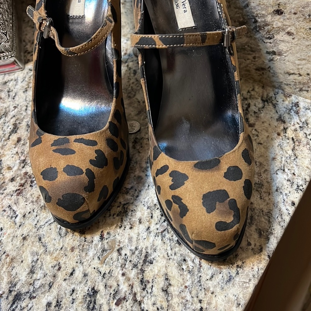 They were weighing high heel with buckle across the top of the shoe